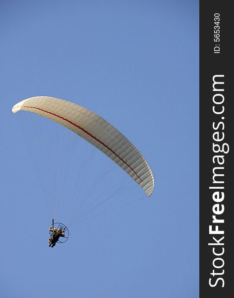 Paraglider with one person on blue sky