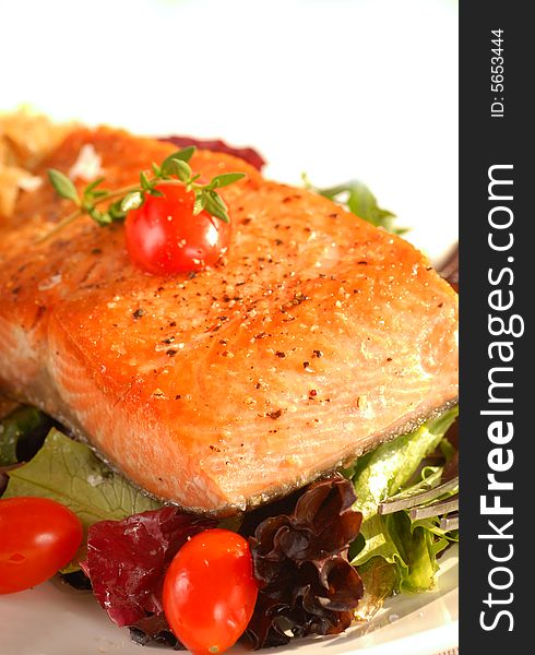 Freshy seared salmon on a bed of greens with tomato and thyme