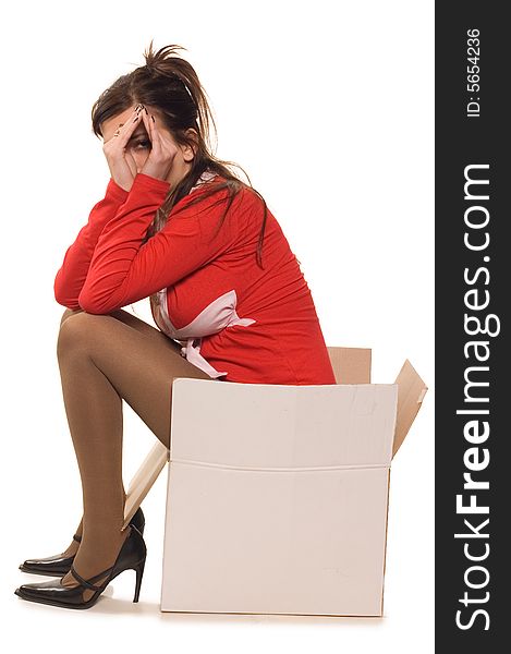 Young woman dressed in red clothes sitting on cardboard box