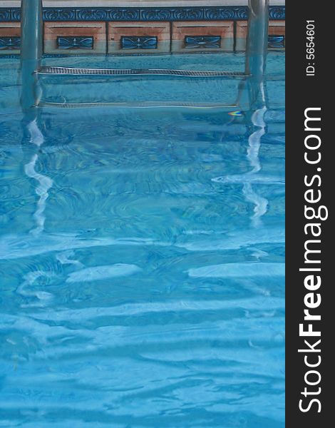 Blue Water and Swimming Pool Steps are Featured in an Abstract Image.