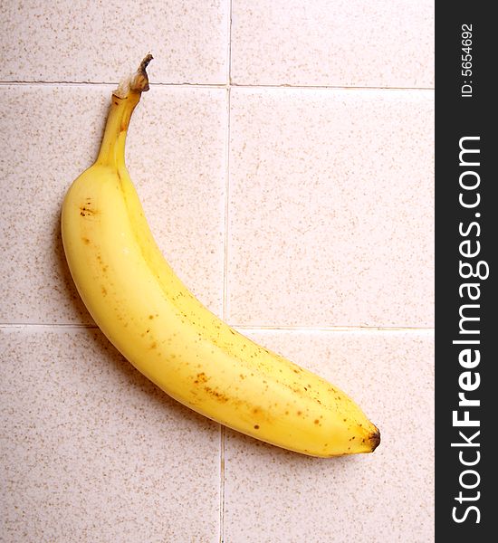 A banana on a kitchen counter top. A banana on a kitchen counter top
