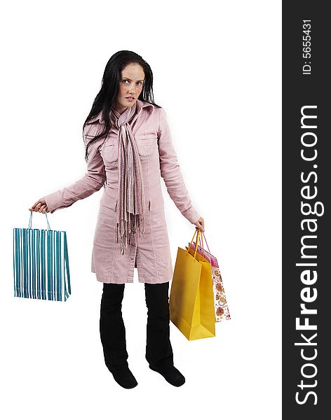 Portrait of a beautiful brunette woman with light blue eyes and freckles on her skin, wearing pink winter jacket and scarf holding colorful shopping bags in her hands. Portrait of a beautiful brunette woman with light blue eyes and freckles on her skin, wearing pink winter jacket and scarf holding colorful shopping bags in her hands