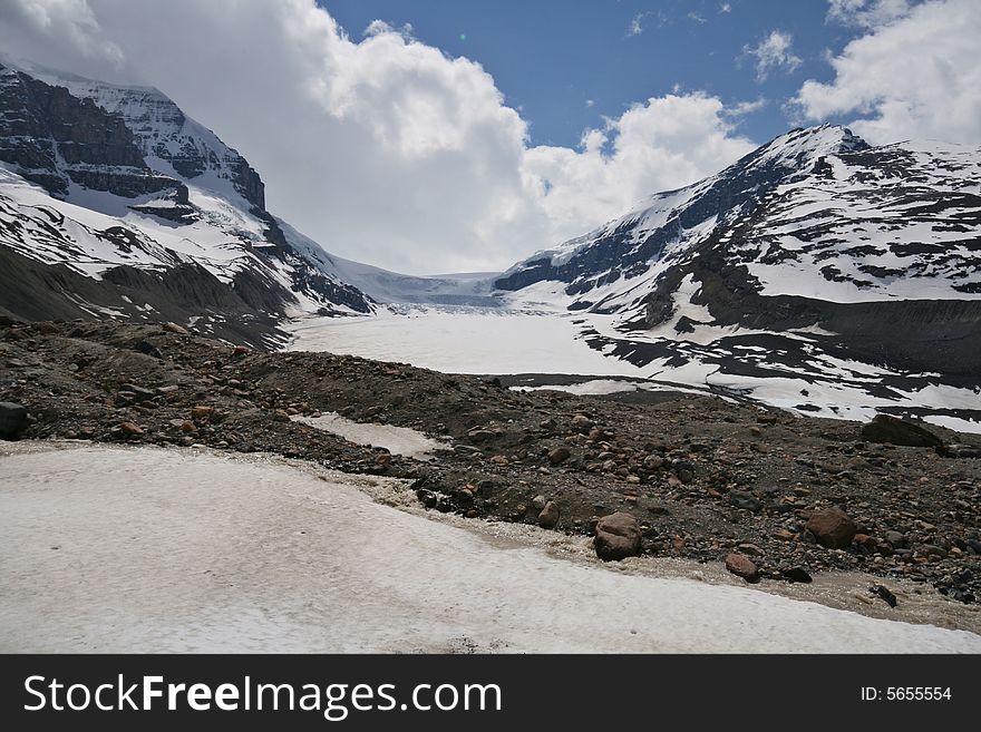 A retreating glacier in a wide valley among the mountain peaks. A retreating glacier in a wide valley among the mountain peaks.