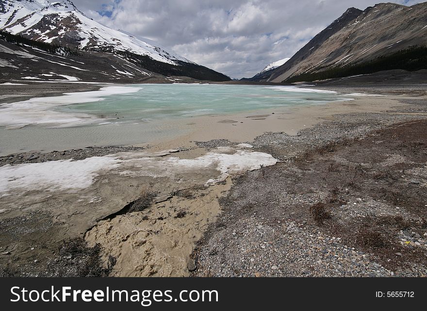 Dirty water running towards a beautiful clear lake. Dirty water running towards a beautiful clear lake.