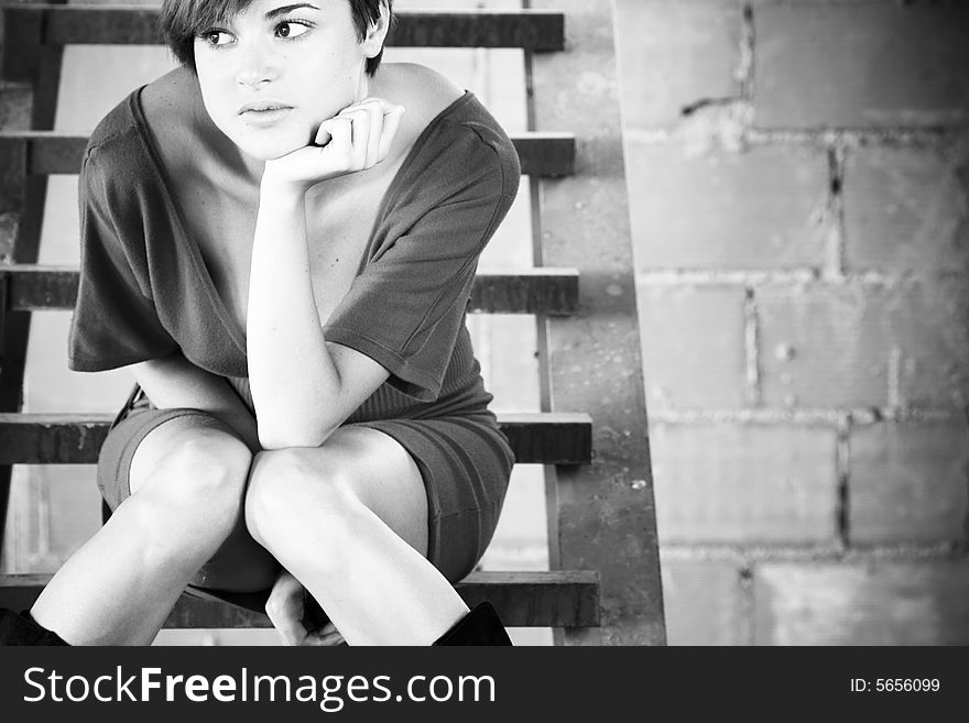 Thoughtful young woman on metal stairs