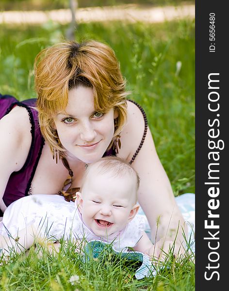 Mother and little child relaxing in the park. Focus point on the child face.