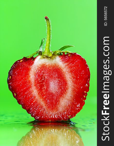 Slice of a strawberry on green background