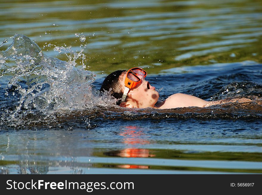 The fast swimming boy in a lake late afternoon. The fast swimming boy in a lake late afternoon.