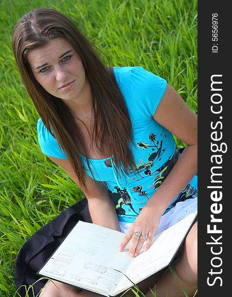 Young woman on the meadow in the summer reading a book. Young woman on the meadow in the summer reading a book.