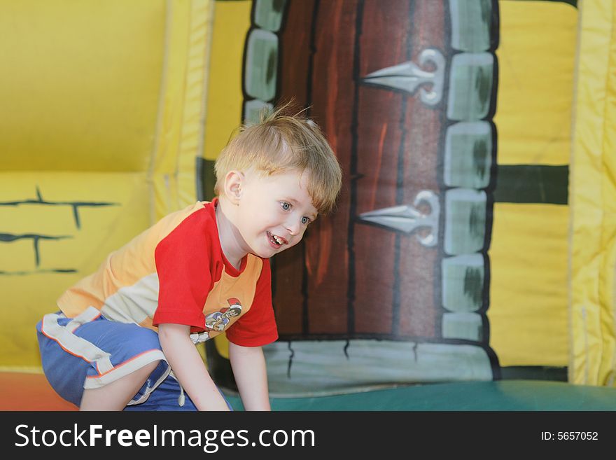 The cheerful kid on an inflatable attraction