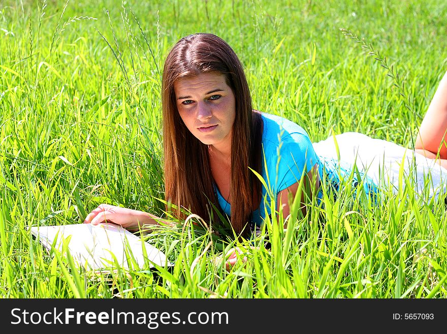 Young woman on the meadow in the summer reading a book. Young woman on the meadow in the summer reading a book.