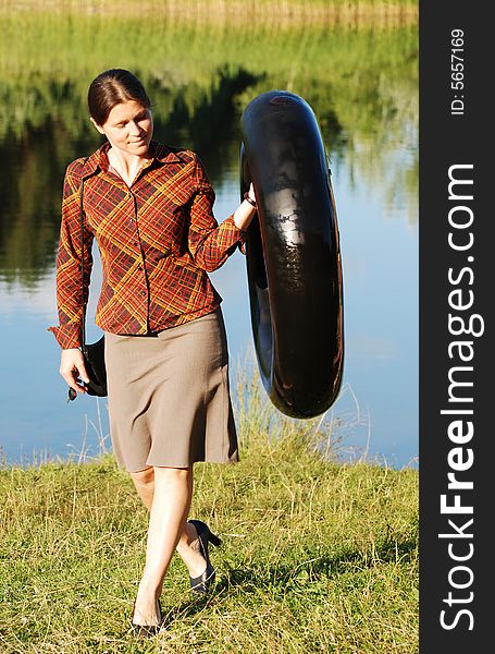 The girl carrying a tube near lake in the evening (Lithuania). The girl carrying a tube near lake in the evening (Lithuania).