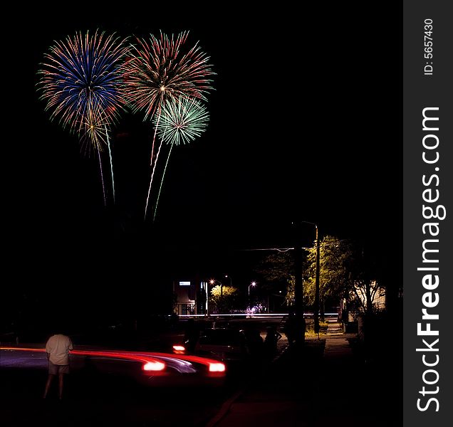 Long exposure of fireworks over an urban street scene. Long exposure of fireworks over an urban street scene