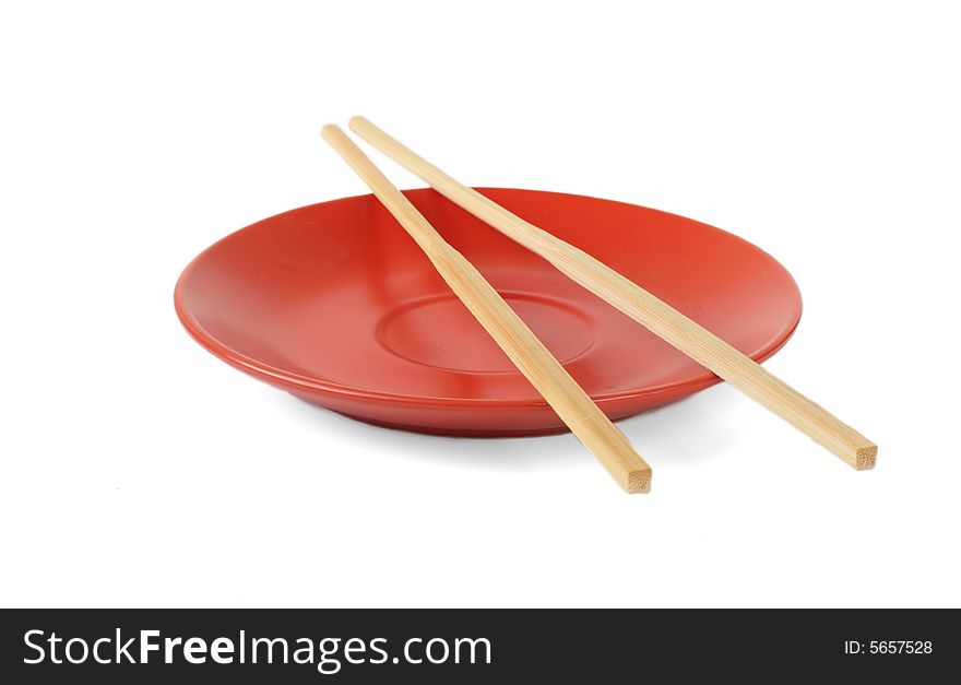 Red plate with bamboo chopsticks isolated on white background