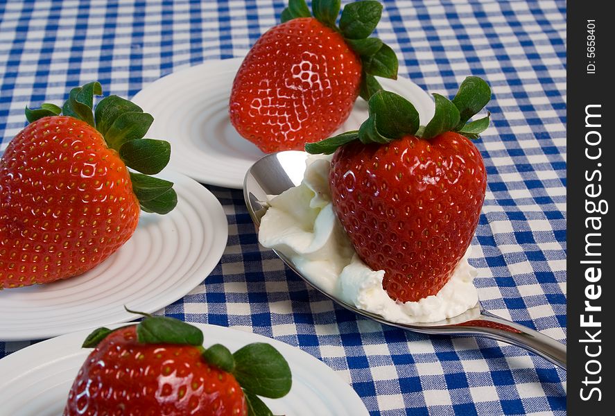 Delicious fresh strawberries with blue gingham tablecloth
