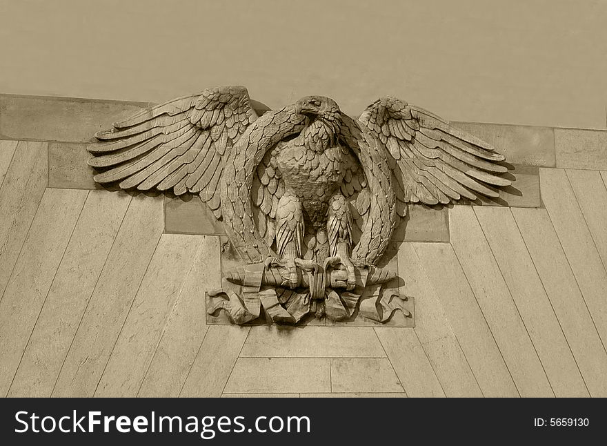 Detail of a building: a brown eagle made of stone. Detail of a building: a brown eagle made of stone.