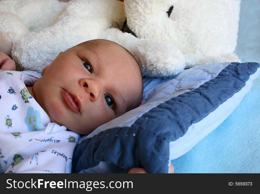 Week old baby boy on a blue blanket early in the morning. Week old baby boy on a blue blanket early in the morning