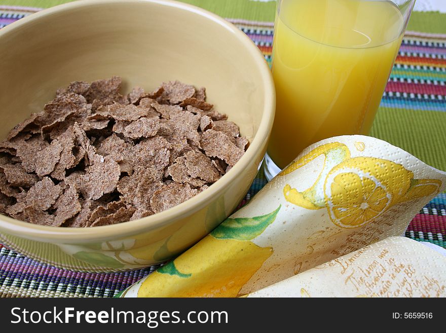 Cereal in a green bowl with orange juice. Cereal in a green bowl with orange juice