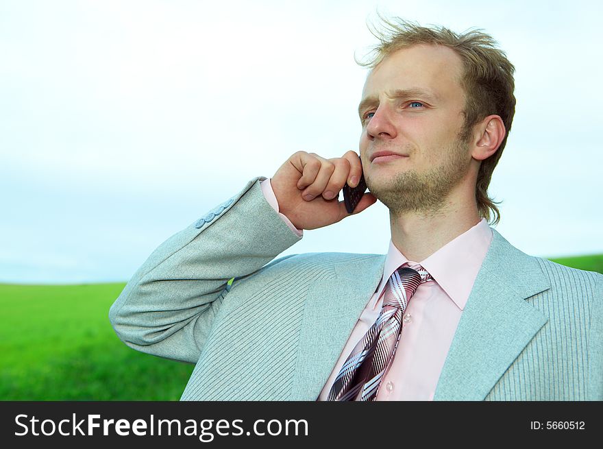 Businessman in field with cellphone