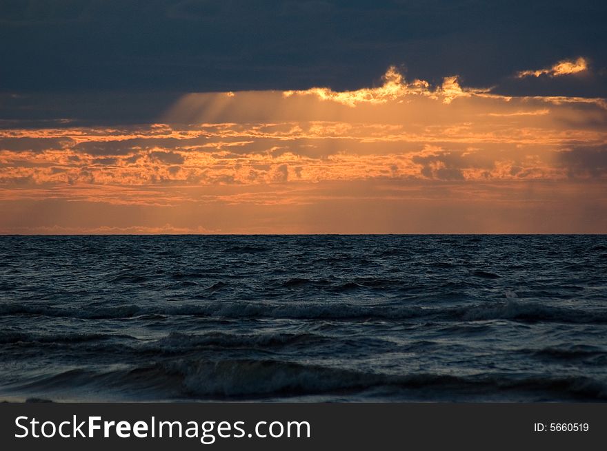 The sea, solar beams, clouds