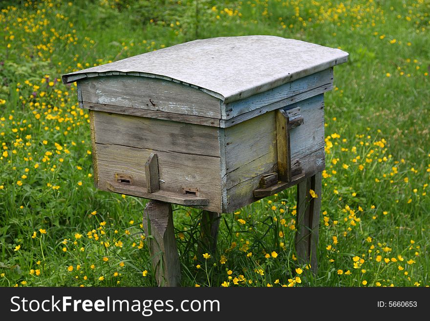 Rural wood bee hive on meadow with bright flowers. Rural wood bee hive on meadow with bright flowers