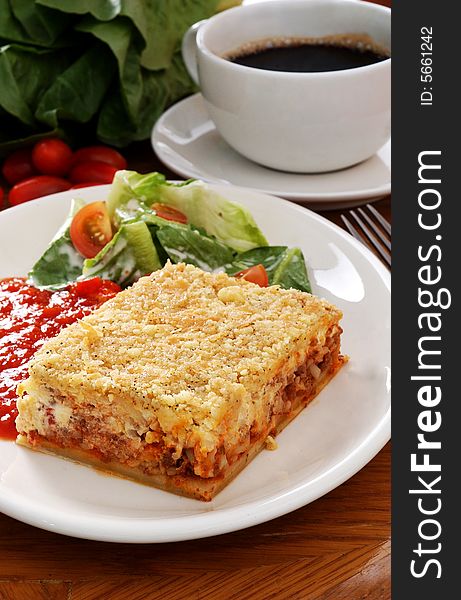 A slice of lasagna with salad