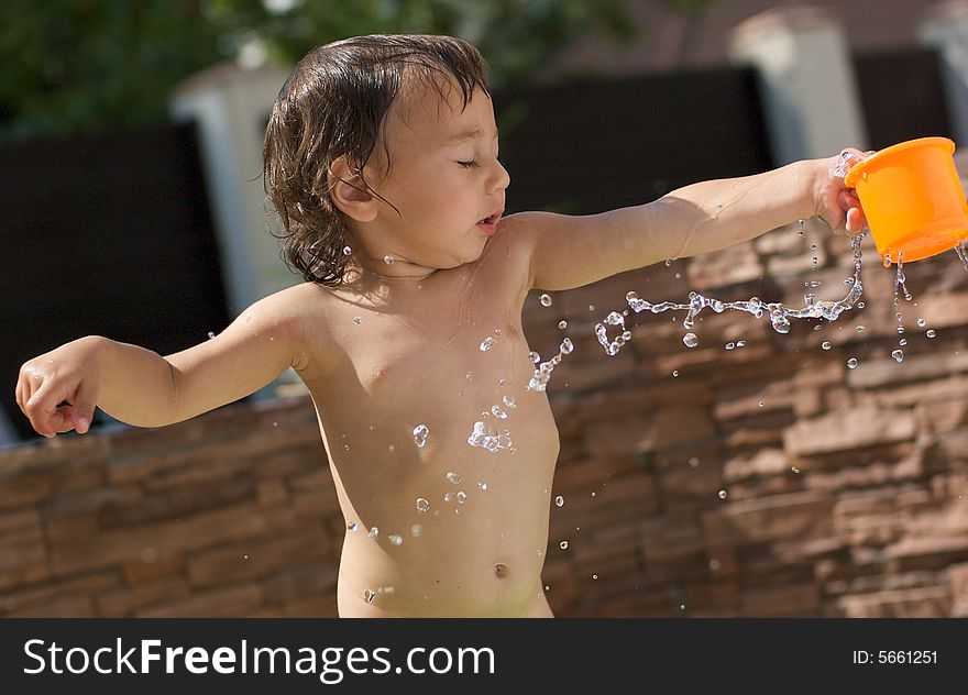 Little boy splashes water on open air
