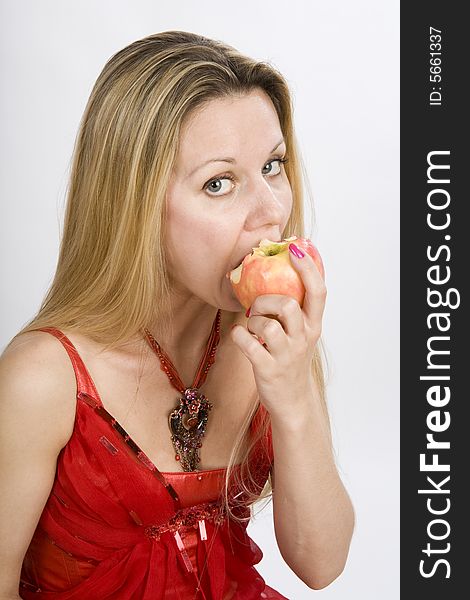 Long hair blonde woman in red with apple in her mouth. Long hair blonde woman in red with apple in her mouth