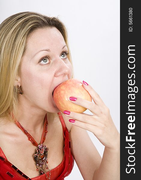 Long hair blonde woman in red with  apple in her mouth. Long hair blonde woman in red with  apple in her mouth