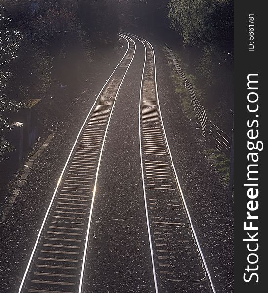 Reflection of setting sun on railway tracks in urban area,Great Britain.