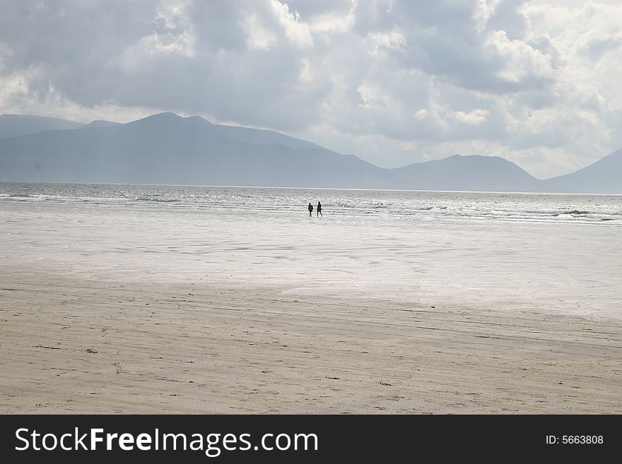 Two people walking on a beach. Two people walking on a beach