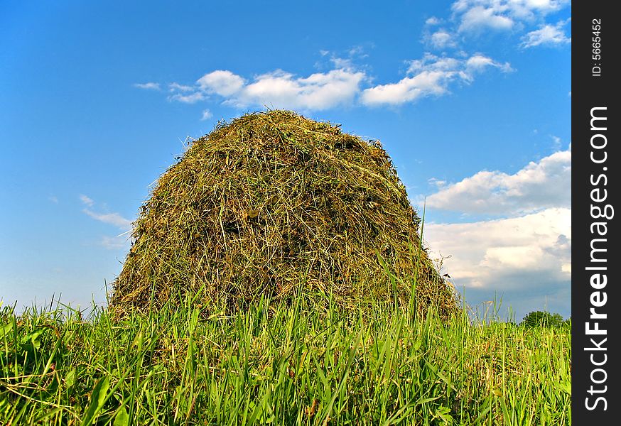 Photo of stacked hay and clouds