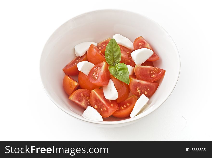 Italian salad made with cherry tomatoes, Mozzarella cheese, and fresh basil. Isolated on white. Italian salad made with cherry tomatoes, Mozzarella cheese, and fresh basil. Isolated on white