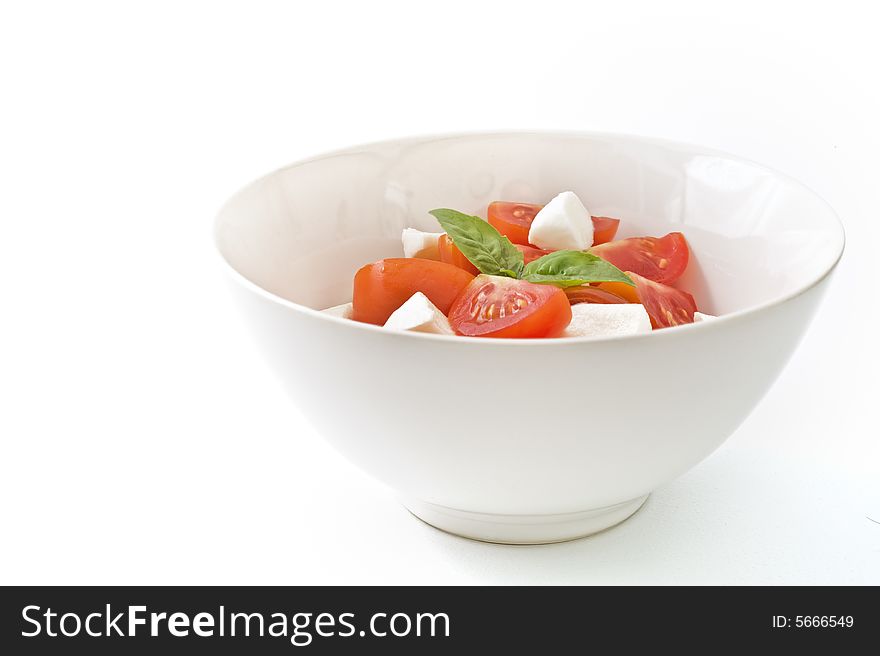 Italian salad made with cherry tomatoes, Mozzarella cheese, and fresh basil. Isolated on white. Italian salad made with cherry tomatoes, Mozzarella cheese, and fresh basil. Isolated on white