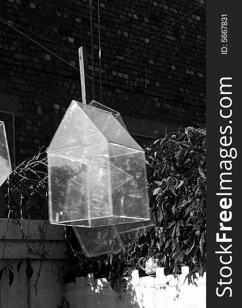 Installation art piece with floating perspex houses suspended on wire to look like polygonal soap bubbles, close up in black and white. Installation art piece with floating perspex houses suspended on wire to look like polygonal soap bubbles, close up in black and white