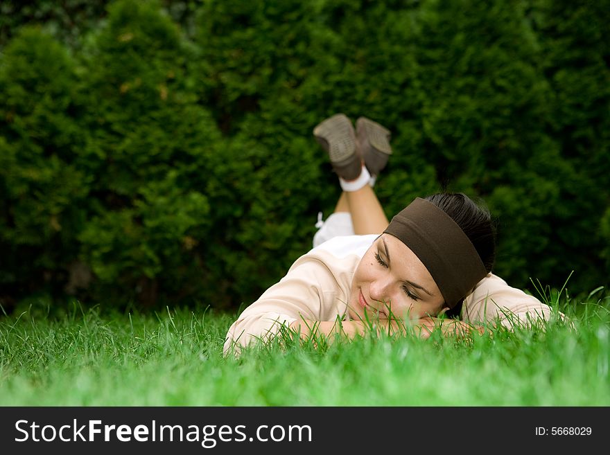 Attractive brunette woman lying on grass. Attractive brunette woman lying on grass