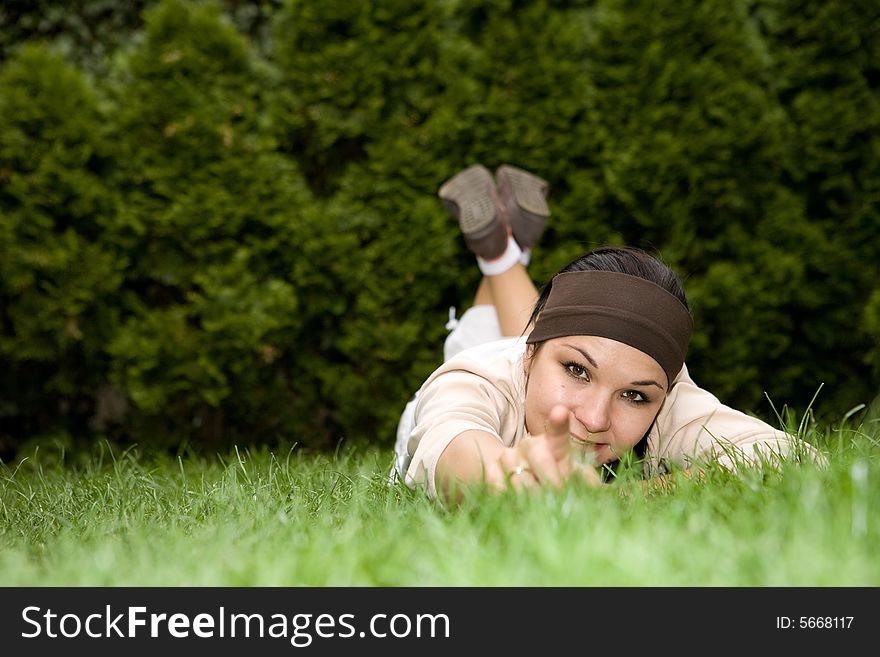 Attractive brunette woman lying on grass. Attractive brunette woman lying on grass