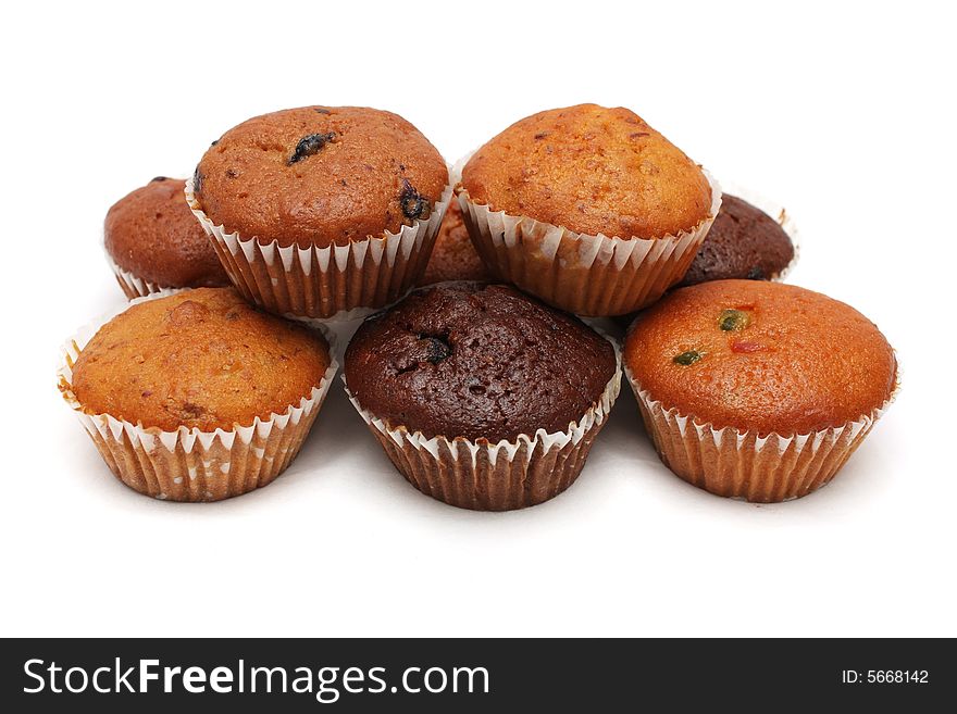 Many muffins stacked together on white background.