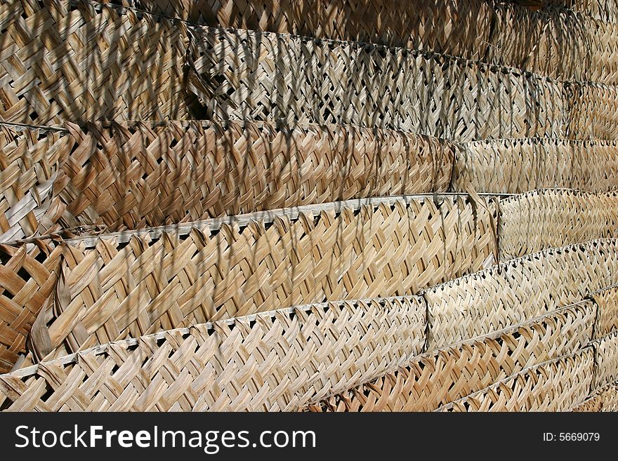 A photo good for backgrounds showing the thatched wall of a hut.