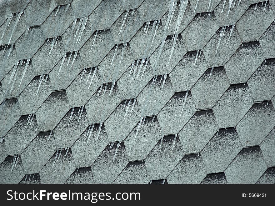 Icicles on a roof from a hexagonal tile. Icicles on a roof from a hexagonal tile