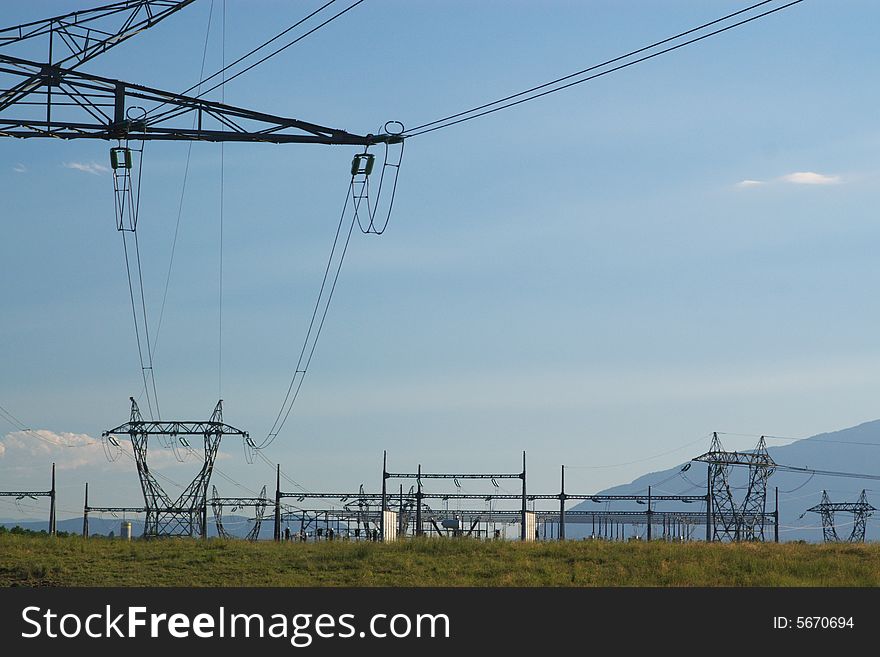 Electrical high voltage power lines, isolators and mast in blue cloudy sky, horizontal. Electrical high voltage power lines, isolators and mast in blue cloudy sky, horizontal.