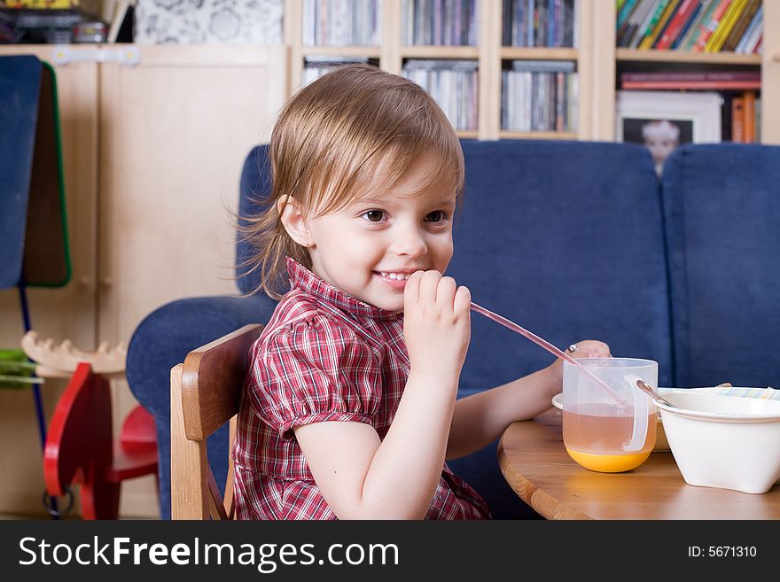 Little girl drinking fresh orange juice and smile