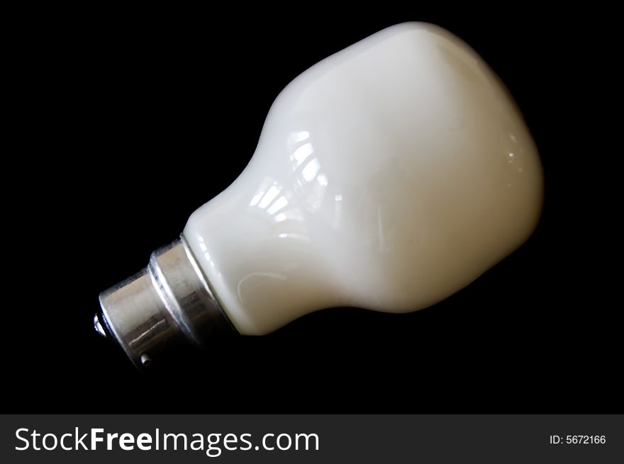 Saving white electric bulb isolated in a black background. Saving white electric bulb isolated in a black background