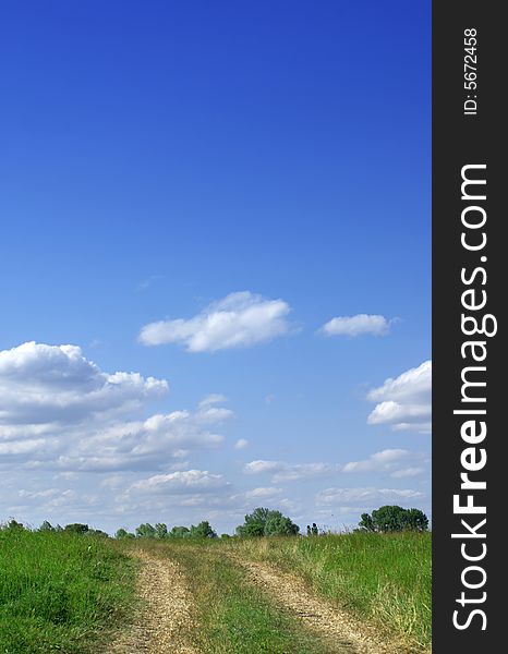 Green field and blue sky landscape with road. Green field and blue sky landscape with road