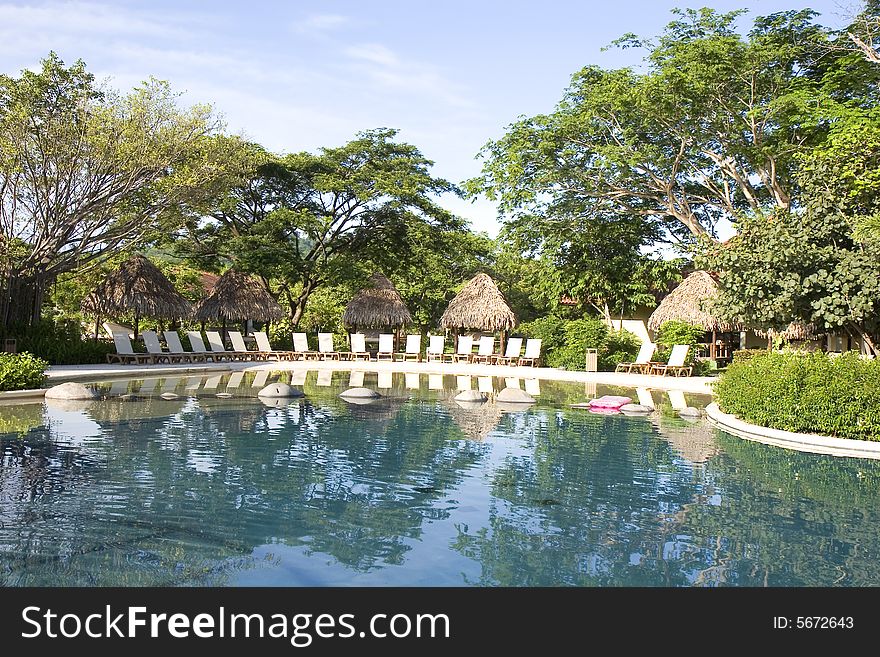 A beautiful resort swimming pool with lounge chairs. A beautiful resort swimming pool with lounge chairs