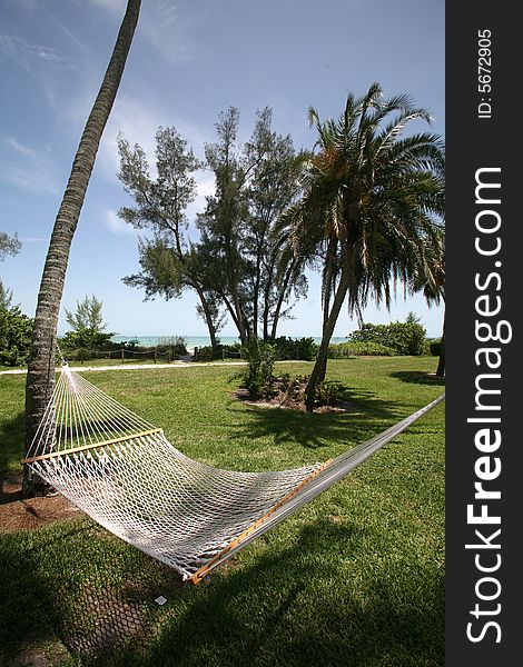 A photo taken of a hammock between two palm trees with the ocean in the background. Photo taken on Sanibel / Captiva Island. A photo taken of a hammock between two palm trees with the ocean in the background. Photo taken on Sanibel / Captiva Island.