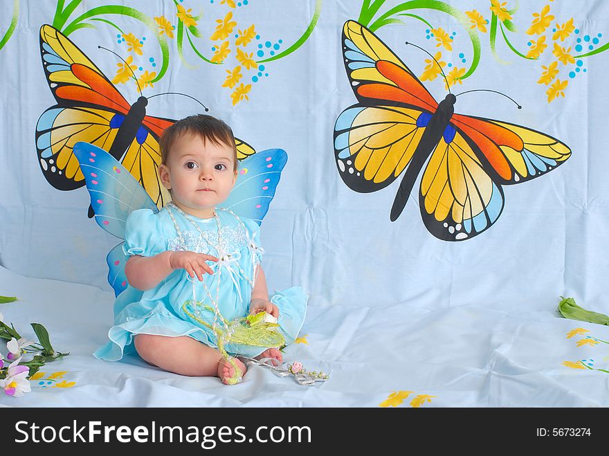 A picture of a sweet little girl in a fancy blue dress with butterfly wings. A picture of a sweet little girl in a fancy blue dress with butterfly wings
