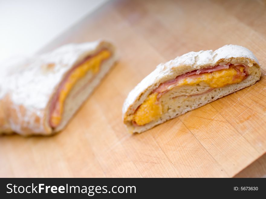 Shallow focus ham and cheese loaf on a wooden cutting board