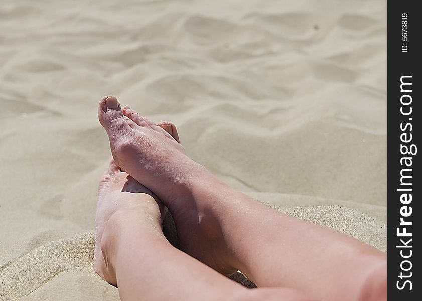 Feet relaxing on sand or beach. Feet relaxing on sand or beach