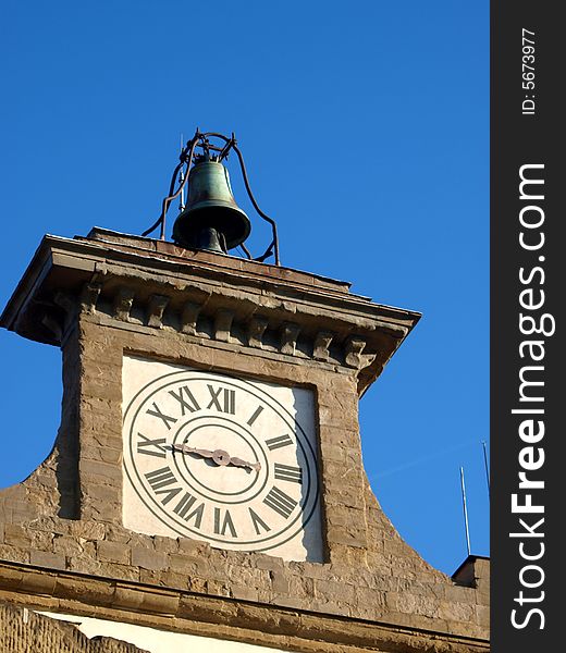 An ancient clock in the facade of a building in Belvedere fortress in Florence with a bell on the top. An ancient clock in the facade of a building in Belvedere fortress in Florence with a bell on the top
